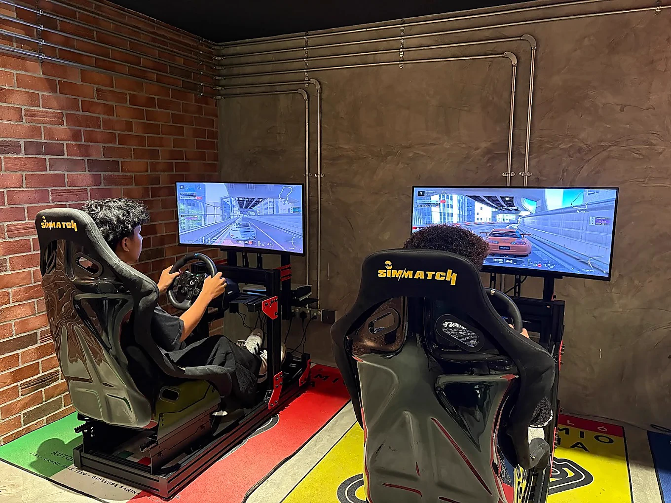 Two guests racing on the twin simulators at Pedal & Rolls